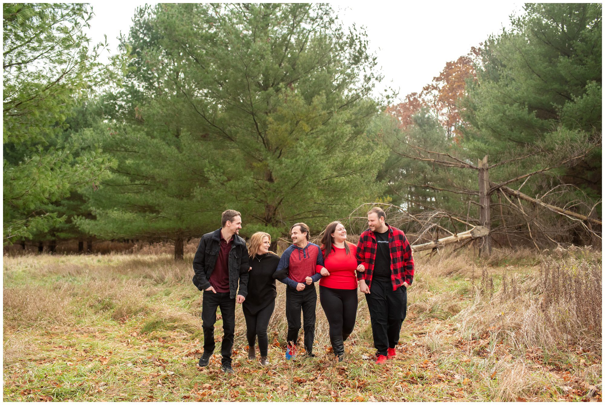 5 people holding hands and walking through a field together at Komoka Provincial Park